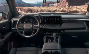 The dashboard and steering wheel of a 2024 GMC Terrain photographed outdoors on a dirt road near Carmel, Indiana