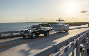 A black 2024 GMC 3500HD towing a boat near Carmel, Indiana