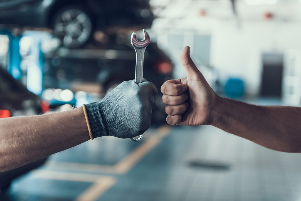 Mechanic’s hand using a tool to repair a vehicle in an auto shop %(big_city1), %(state) %(dealership_name).
